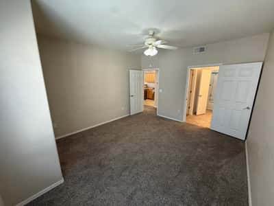 Large bedroom offering easy access to the bathroom and walk-in closet. Soft carpeting and neutral tones create a warm and inviting atmosphere.