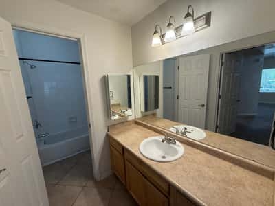 Functional bathroom space with an oversized mirror, spacious vanity countertop, updated lighting, and ample cabinet storage. Neutral finishes enhance the move-in-ready appeal of this Phoenix property.