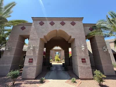 Architecturally striking clubhouse entrance framed by mature palm trees and attractive desert landscaping. This Phoenix community provides residents with access to appealing shared amenities and gathering spaces.