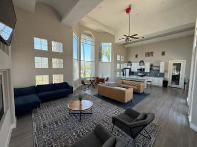 Stunning clubhouse interior featuring vaulted ceilings, expansive windows, stylish seating areas, and contemporary finishes. This exceptional Phoenix community amenity creates an inviting place to relax and connect.