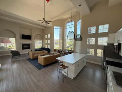 Expansive clubhouse great room showcasing a modern kitchen, oversized island, soaring ceilings, and bright gathering spaces. This impressive Phoenix community amenity offers exceptional versatility for residents and guests.