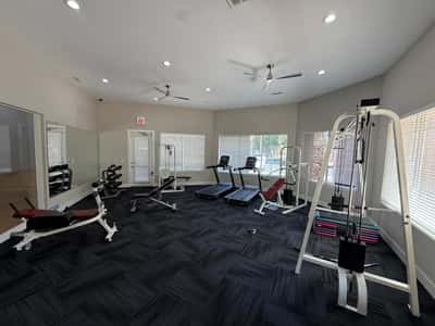 Community fitness room equipped with strength-training equipment, treadmills, free weights, and mirrored walls. An attractive Phoenix amenity that adds convenience and value to everyday living.