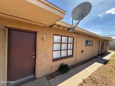 Inviting exterior entry featuring a security door, large front-facing window, and covered walkway access. The simple, functional design offers both convenience and curb appeal for everyday living.