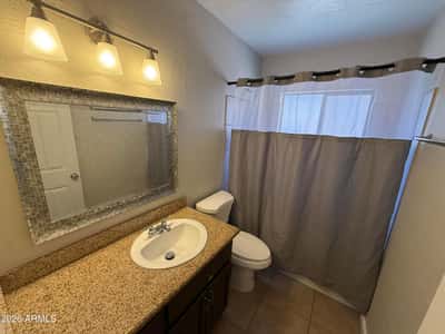 Bathroom featuring an upgraded vanity, decorative framed mirror, modern lighting, and a tub-shower combination. Neutral finishes provide a fresh and timeless appearance.