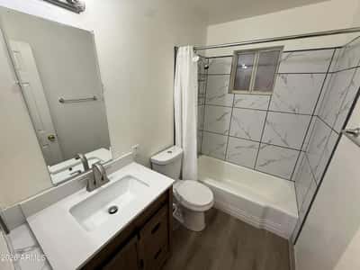 Beautifully updated bathroom showcasing a contemporary vanity, modern faucet, designer tile shower surround, and clean finishes. The stylish upgrades create a fresh and inviting space for daily routines.