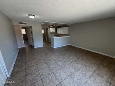 Open-concept living room featuring expansive floor space, low-maintenance finishes, and easy access to the kitchen. Ideal for comfortable living and entertaining guests.