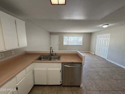 Kitchen overlooking the living area with breakfast bar, dual sink, ample storage, and included appliances. The open design supports both entertaining and daily family interaction.