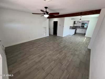 Featuring updated flooring, decorative beam details, and an open-concept design, this spacious living area provides flexibility for relaxing, entertaining, and creating your ideal home setup.