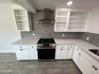 Elegant quartz surfaces, stainless steel appliances, and abundant cabinetry highlight this beautifully updated kitchen. The thoughtful design blends storage, efficiency, and contemporary style.