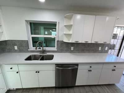 Extensive countertops, open shelving, and quality finishes make this kitchen both attractive and practical. Perfect for meal preparation, organization, and entertaining guests.