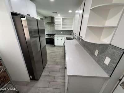 Offering generous cabinetry, stainless steel appliances, quartz countertops, and stylish finishes, this remodeled kitchen delivers the storage and workspace today's buyers are seeking.
