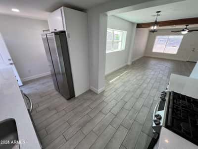 The open floor plan creates an effortless flow between the remodeled kitchen and living spaces. Quartz countertops, stainless steel appliances, and modern flooring contribute to the home's contemporary appeal.
