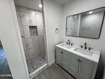 Featuring a sleek double vanity, contemporary hardware, and a stunning tiled shower, this renovated bathroom delivers both comfort and style. Elegant finishes and thoughtful updates enhance the home's overall appeal.