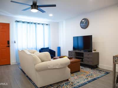 This beautifully updated living room offers modern flooring, fresh finishes, and flexible furniture arrangements. The open design enhances natural flow throughout the home and creates an inviting environment.