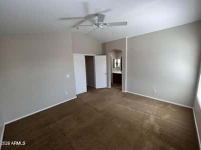 Enjoy a spacious primary bedroom featuring soft carpeting, vaulted ceilings, and direct access to the ensuite bathroom. The generous size creates a relaxing retreat at the end of the day.
