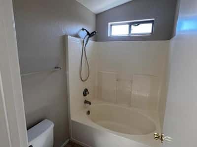 Featuring a tub and shower combination, tile flooring, and natural light, this bathroom offers practical functionality for family members and guests alike.