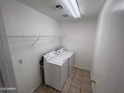 Dedicated laundry space with included appliances, storage shelving, and room for household organization. A valuable feature that helps simplify everyday living.