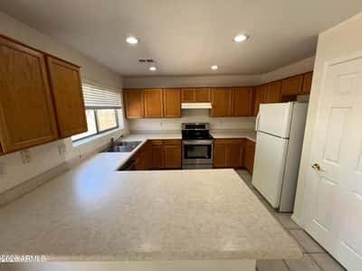 Designed for functionality, this kitchen offers extensive countertops, abundant cabinetry, and recessed lighting. The spacious peninsula provides additional prep space and room for casual seating.