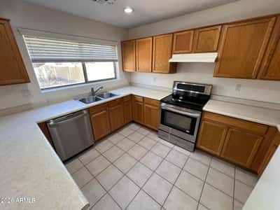 Bright and welcoming, this kitchen includes stainless steel appliances, abundant cabinet storage, and expansive work surfaces. Large windows bring in natural light while overlooking the backyard.