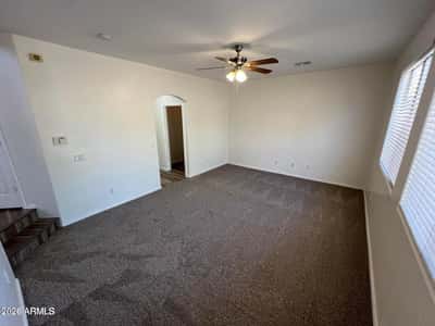 Spacious primary bedroom with soft carpeting, neutral color palette, and plenty of room for oversized furnishings. The comfortable layout creates a relaxing owner's retreat.