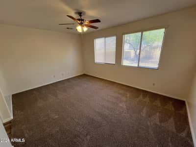 Enjoy the comfort of this spacious primary suite featuring plush carpeting, abundant natural light, and plenty of room for oversized furnishings. The inviting layout creates a peaceful retreat at the end of the day.