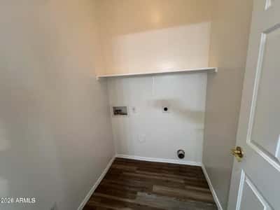 Functional laundry room with utility connections, storage shelf, and easy-care flooring. Designed for convenience, this space helps simplify everyday household routines.