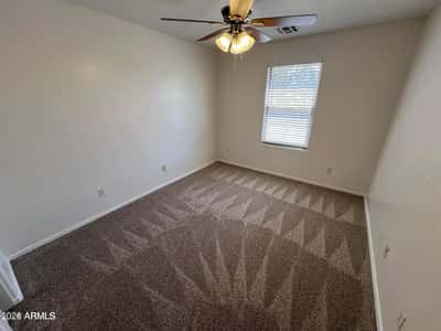 Spacious bedroom with plush carpeting, neutral finishes, and a comfortable layout suitable for guests, family members, hobbies, or a home office.