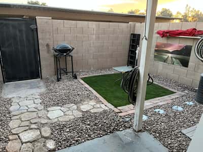 Enjoy a private fenced backyard with a covered patio, artificial turf, decorative rock landscaping, and room for outdoor dining or barbecuing. This low-maintenance outdoor area extends the home's comfortable living space in Glendale.