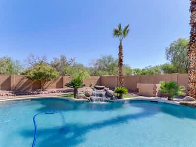 Enjoy your own private backyard retreat with a resurfaced PebbleTec play pool, tranquil waterfall, mature landscaping, and plenty of patio space for relaxing, entertaining, or enjoying Arizona sunshine.