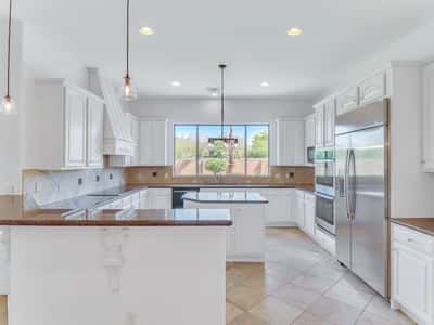 Beautiful kitchen with granite countertops, custom cabinetry, stainless steel appliances, center island, and abundant workspace. Thoughtfully designed for cooking, entertaining, and gathering with family and friends.
