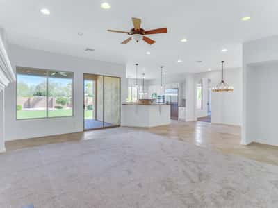 Spacious great room seamlessly connects the kitchen, dining, and living spaces with soaring ceilings, neutral finishes, and abundant natural light. The open layout offers flexibility for entertaining and everyday living.
