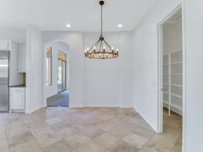Bright dining area accented by a modern chandelier and surrounded by neutral finishes that complement any d cor. Conveniently located adjacent to the kitchen for easy entertaining and family gatherings.
