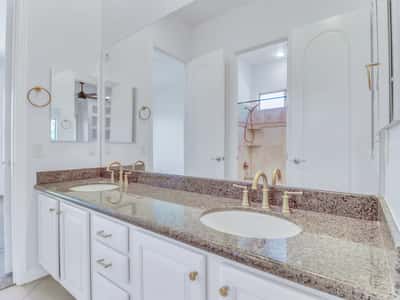 A spacious granite countertop with dual sinks, generous cabinetry, and quality fixtures creates a functional and elegant bathroom. This Glendale home showcases thoughtful design and everyday comfort.