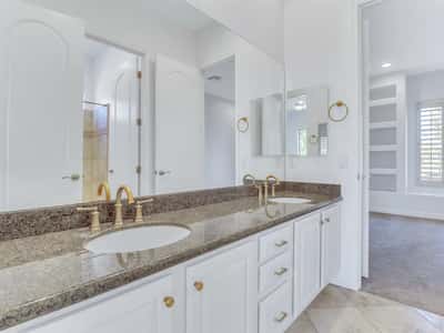 Well-appointed bathroom with dual sinks, granite counters, oversized mirror, abundant cabinetry, and quality fixtures designed for everyday convenience in this Glendale home.