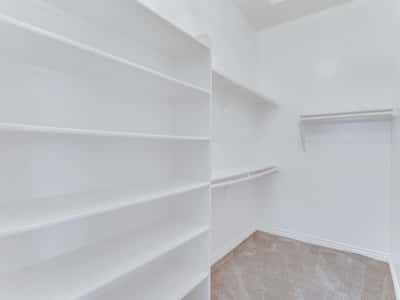 Enjoy exceptional storage with built-in shelving, generous hanging space, and plush carpeting in this oversized walk-in closet. Designed to maximize organization and everyday convenience in this Glendale home.