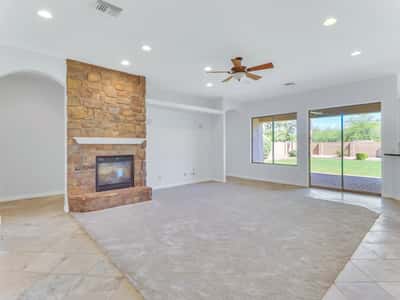 The spacious great room showcases a dramatic floor-to-ceiling stone fireplace, recessed lighting, large windows, and sliding doors opening to the backyard. This Glendale home offers exceptional comfort for everyday living and entertaining.