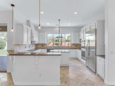 Bright kitchen featuring stainless steel appliances, granite counters, center island, breakfast bar, and abundant cabinetry. Designed for entertaining and everyday living in this beautiful Glendale home.