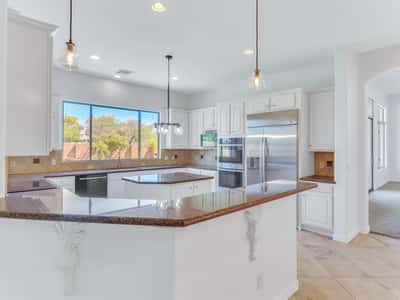 Open kitchen featuring granite countertops, stainless steel appliances, custom cabinetry, center island, pendant lighting, and generous workspace. This Glendale property offers an ideal layout for cooking and entertaining.