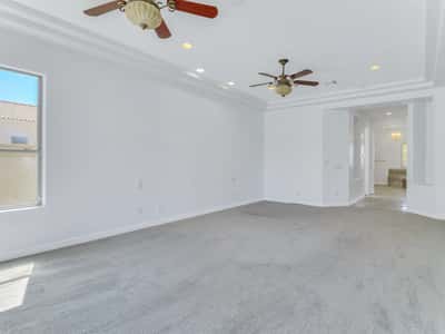 Spacious owner's suite featuring tray ceilings, dual ceiling fans, plush carpeting, recessed lighting, and a bright, open layout. This Glendale property delivers comfort and generous bedroom space.