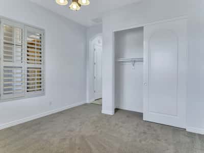 This inviting bedroom offers plush carpeting, plantation shutters, a large closet with sliding doors, and plenty of natural light. Comfortable living spaces enhance the appeal of this Glendale home.