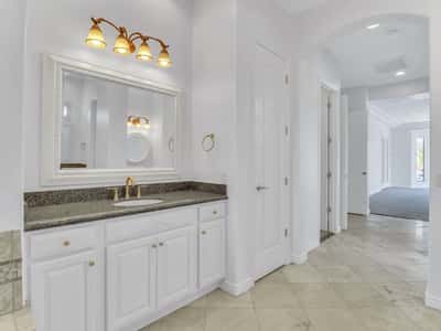 Granite countertops, elegant fixtures, custom cabinetry, and a generous vanity create a functional and stylish bathroom with timeless finishes in this Glendale property.