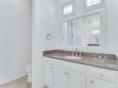 Featuring granite countertops, custom cabinetry, decorative mirror, and premium fixtures, this bathroom combines classic design with everyday functionality in this beautifully maintained Glendale residence.