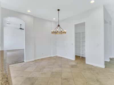 Elegant dining area featuring modern chandelier lighting, tile flooring, and an open connection to the kitchen and living spaces. This Glendale home offers a welcoming atmosphere for gatherings.