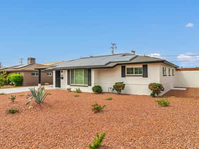 Attractive remodeled mid-century ranch home featuring fresh landscaping, modern exterior finishes, and a high-efficiency 36-panel solar system. This Phoenix rental offers outstanding curb appeal and reduced energy costs.
