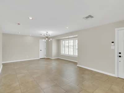 Spacious family room highlighted by plantation shutters, updated finishes, recessed lighting, and an open layout that provides comfortable living space for relaxing or entertaining in this Phoenix rental home.