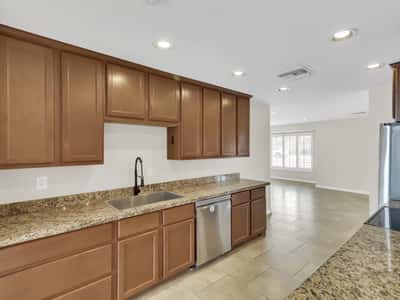 Open kitchen with granite surfaces, stainless steel appliances, plentiful storage, and excellent connection to the living areas provides a practical and inviting heart of this remodeled Phoenix rental.