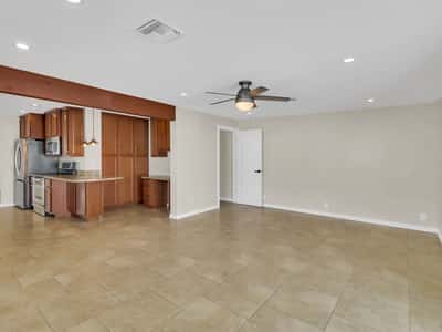 Expansive living area featuring neutral finishes, tile flooring, ceiling fan, and direct access to the updated kitchen. This Phoenix rental offers versatile space for relaxing, entertaining, or working from home.