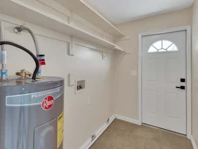 Functional utility room with built-in shelving, utility hookups, and additional storage for household essentials. This practical feature adds everyday convenience to this remodeled Phoenix rental.