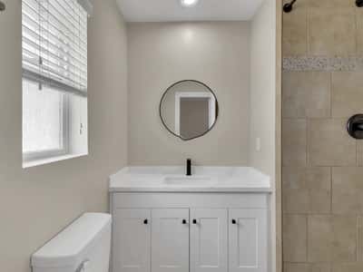 Beautifully updated bathroom with quartz countertop, white shaker cabinetry, matte black fixtures, and designer tile accents. A fresh, modern upgrade within this remodeled Phoenix rental.