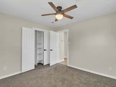 Well-sized bedroom featuring soft carpeting, ceiling fan, built-in closet organization, and clean neutral finishes. This comfortable space completes the updated interior of this Phoenix rental.